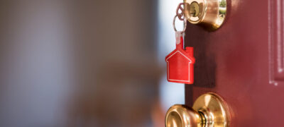 House Key In The Door Opening Into Apartment