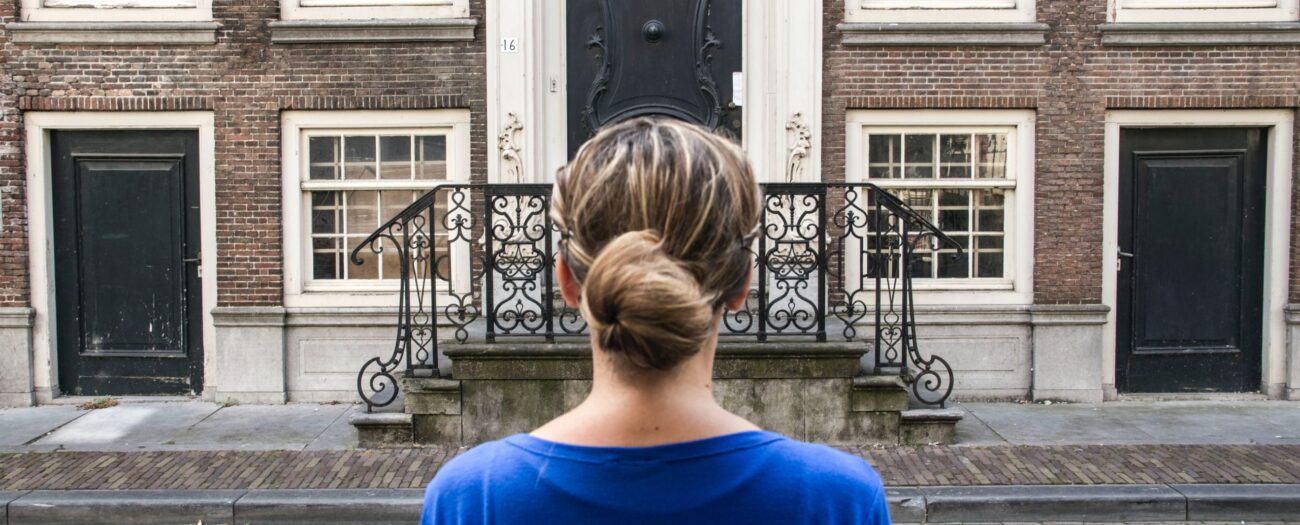 Woman standing outside her potential single family rental starting her self-guided tour