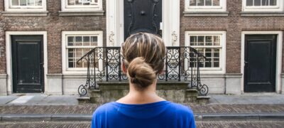 Woman standing outside her potential single family rental starting her self-guided tour