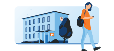 woman walks while looking at her phone on a student housing tour