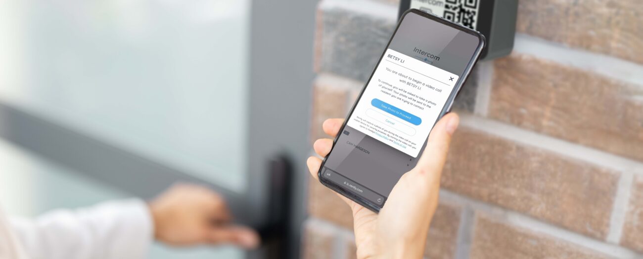 Person using smartphone to access virtual resident directory at a building entrance